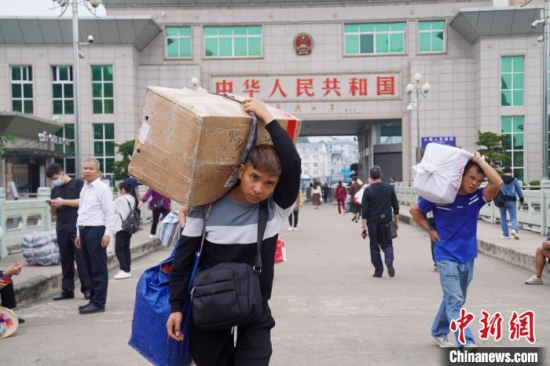 邊民背著大包小包前往越南方向。王以照 攝